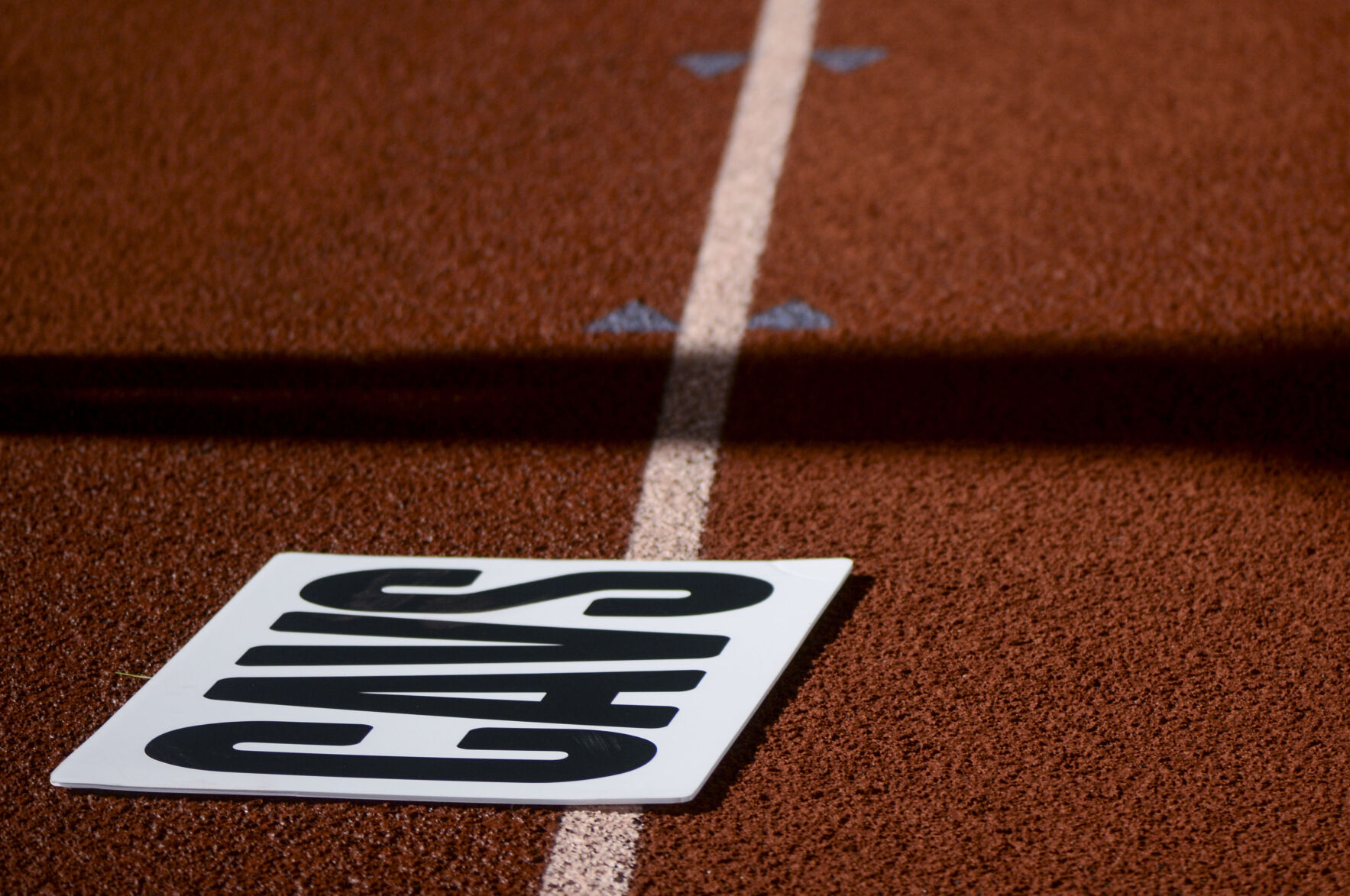 The Capital City cheer team’s sign saying “CAVS” lies on the track while the Cavaliers face the Kirksville Tigers
